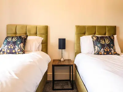 two beds sitting next to each other in a room at Bodaioch Hall in Caersws