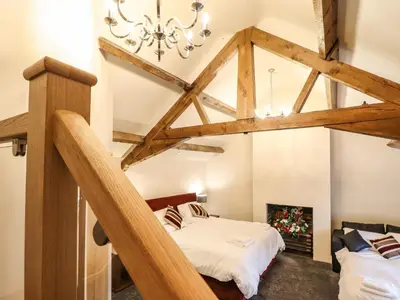 a bedroom with a loft conversion with wooden beams at Bodaioch Hall in Caersws