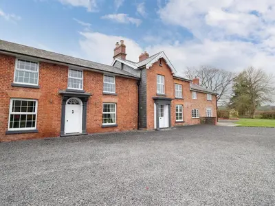 a large brick building with a driveway in front of it at Bodaioch Hall in Caersws
