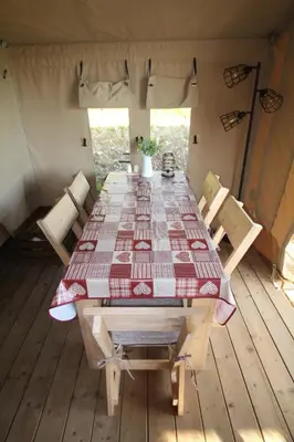 a long table in a tent with a table and chairs at Safari Tent with Hot Tub in heart of Snowdonia in Dolgellau