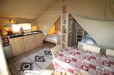a room with a tent with a bed and a kitchen at Safari Tent with Hot Tub in heart of Snowdonia in Dolgellau