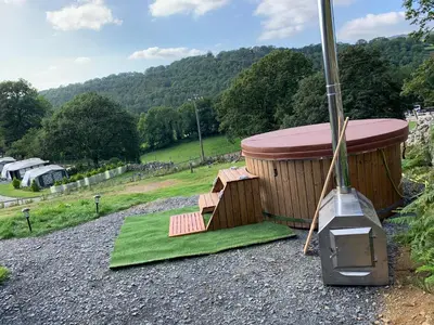a hot tub with a grill and a green towel at Safari Tent with Hot Tub in heart of Snowdonia in Dolgellau