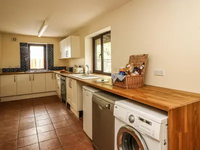 a kitchen with a washer and dryer on a counter at Pant Y Rhedyn in Llandrindod Wells