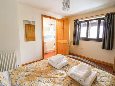 a bedroom with a bed with two towels on it at Pant Y Rhedyn in Llandrindod Wells