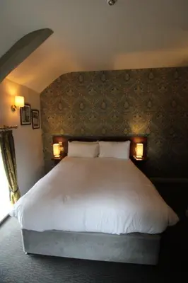 a bedroom with a large white bed with two lamps at rooms @ the dolau inn in New Quay