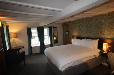 a bedroom with a large white bed and a window at rooms @ the dolau inn in New Quay