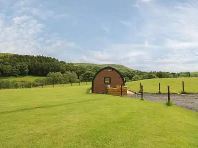 a small barn in a field with a fence at Seren in Llandrindod Wells