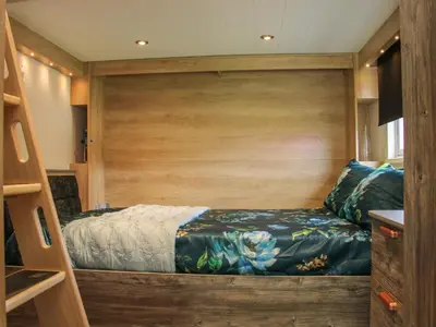 a small bedroom with a bed in a boat at Jacob's Meadow Pod 2 in Shrewsbury
