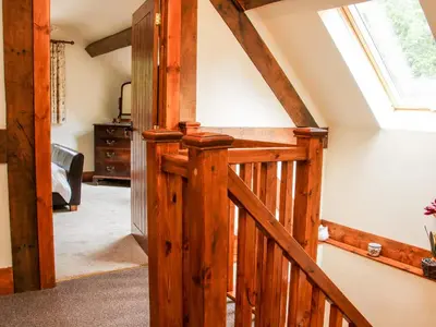a wooden staircase in a house with a skylight at Pool Barn in Craven Arms