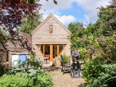 a small house in the middle of a garden at Pool Barn in Craven Arms