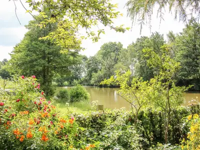 a view of a river from a garden with flowers at Pool Barn in Craven Arms