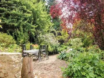 a table and chairs sitting in a garden at Pool Barn in Craven Arms