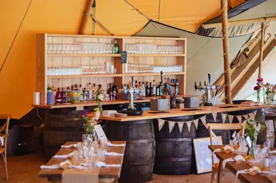 a bar in a tent with tables and chairs at Winsley Park Farm in Leominster
