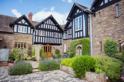 an exterior view of a house with a courtyard at Winsley Park Farm in Leominster
