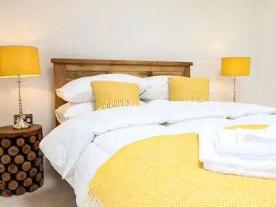 two beds with white sheets and yellow pillows in a bedroom at Swallows Rest in Montgomery