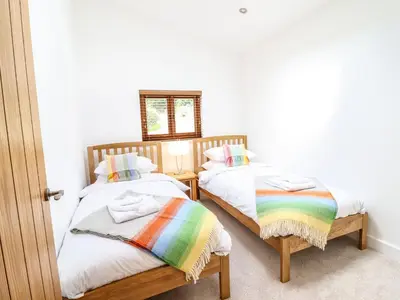 two twin beds in a room with a rainbow blanket at Swallows Rest in Montgomery