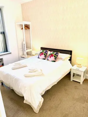 a bedroom with a large white bed with two pillows at Bellaview Apartment Barmouth in Barmouth