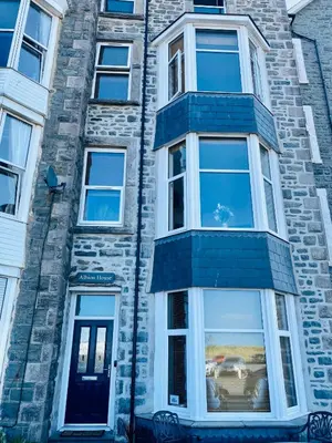 a tall brick building with a blue and white window at Bellaview Apartment Barmouth in Barmouth