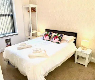 a bedroom with a white bed with towels on it at Bellaview Apartment Barmouth in Barmouth