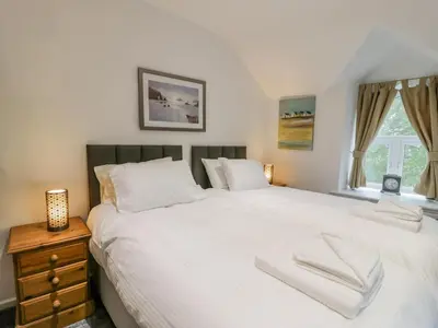 a bedroom with a large white bed and a window at Cae Lleci in Dolgellau