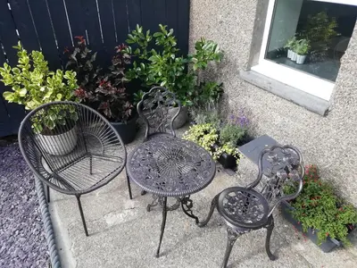 a patio table and two chairs and some plants at Minffordd in Blaenau-Ffestiniog
