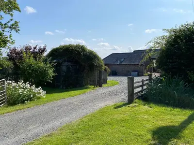 a gravel road leading to a house with a fence at The Retreat in Bredwardine