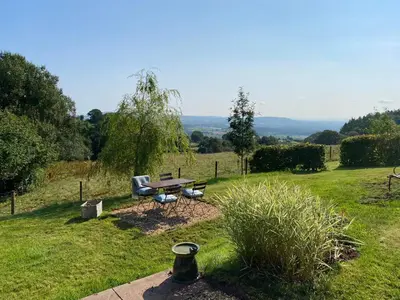 a picnic table and a bench in a field at The Retreat in Bredwardine