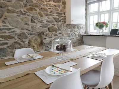 a dining room table with a stone wall at The Toll House in Dolgellau