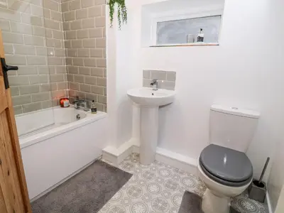a bathroom with a toilet and a sink and a bath tub at The Toll House in Dolgellau