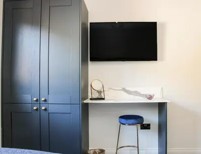a bedroom with a blue cabinet and a blue stool at Meadow View in Meifod