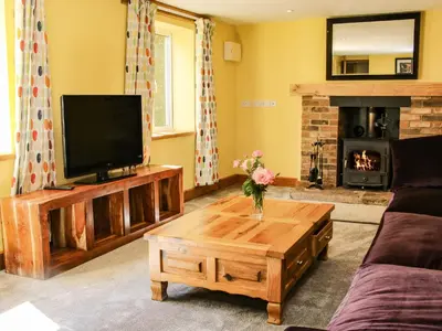 a living room with a tv and a coffee table at Sunnyside in Leominster
