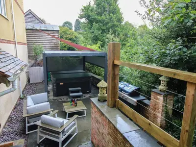 a balcony with a patio furniture and a large screen tv at Sunnyside in Leominster