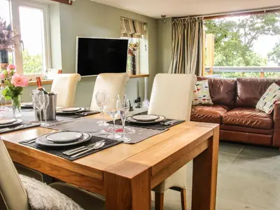 a dining room with a table and a couch at Sunnyside in Leominster