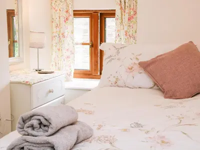 a bedroom with a bed with a towel on it at Linley Lane Cottage in Bishops Castle