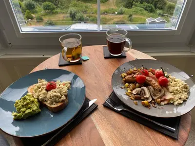 two plates of food on a wooden table with drinks at No6 in Barmouth