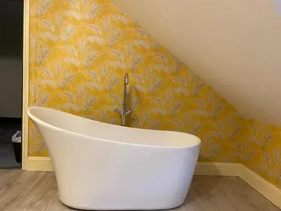 a bath tub in a bathroom with a yellow wall at No6 in Barmouth