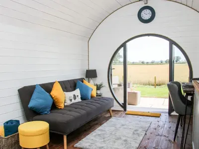 a living room with a black couch and an archway at Withy Willows in Craven Arms