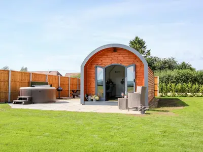 a small shed in a garden with a lawn at Withy Willows in Craven Arms