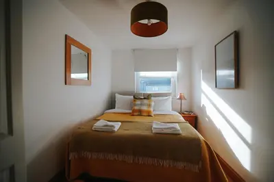 a bedroom with a bed with two towels on it at 13 Tabernacle Street - Aberaeron in Aberaeron