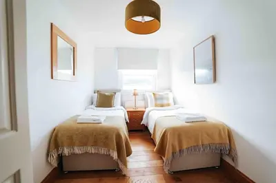 two beds in a room with white walls at 13 Tabernacle Street - Aberaeron in Aberaeron