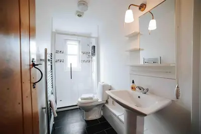a white bathroom with a toilet and a sink at 13 Tabernacle Street - Aberaeron in Aberaeron