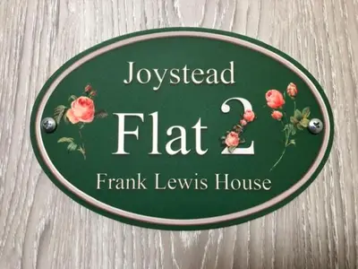 a green sign for a josselected flat family lewis house at Flat 2 Frank Lewis House in Hay-on-Wye