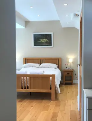 a bedroom with a bed and a wooden floor at 2 Bed Rural cottage between the mountains and Sea in West Wales in Lampeter