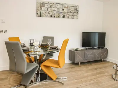 a dining room with a table and chairs and a tv at 42 Albury Place in Shrewsbury