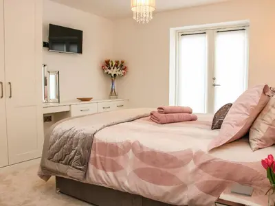 a bedroom with a large bed and a tv at 42 Albury Place in Shrewsbury