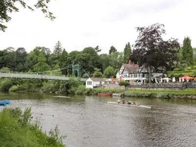 a group of people in a boat on a river with a bridge at 42 Albury Place in Shrewsbury