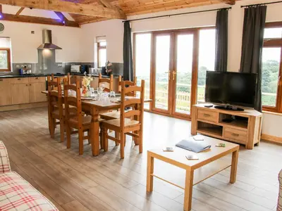 a kitchen and dining room with a table and a television at Toot View in Ludlow
