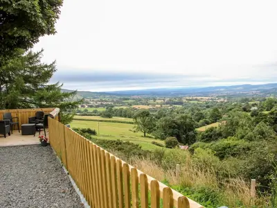 a view from the garden of a house with a wooden fence at Toot View in Ludlow