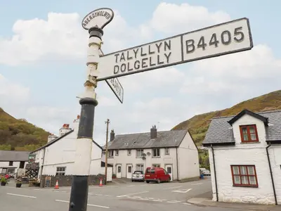 a street sign on a pole in a small town at Arthurs Cottage in Tywyn