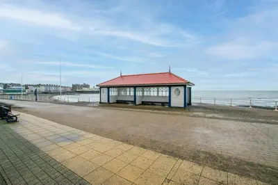 a building with a red roof next to the ocean at 1 Bed in Aberystwyth oc-bow285 in Aberystwyth